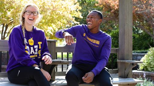 Man and woman sitting on bench laughing